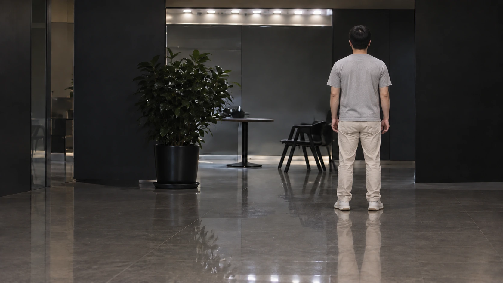 Approximate natural-color reconstruction of a man standing with his back to the camera to the right of a plant and table in an indoor room
